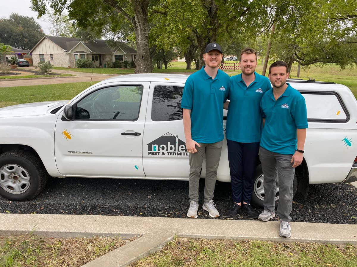 The Noble Pest & Termite team standing in front of a branded service truck in Houston