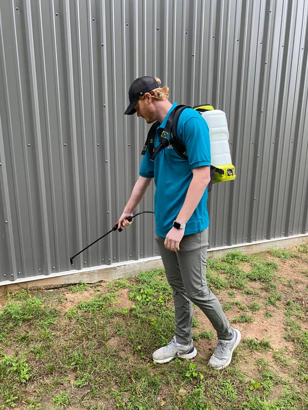 Noble technician treating the exterior perimeter of a building